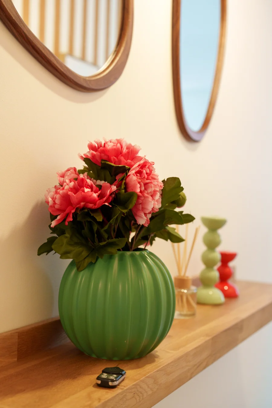 Décoration de l'entrée avec vase vert, fleurs et miroirs en bois