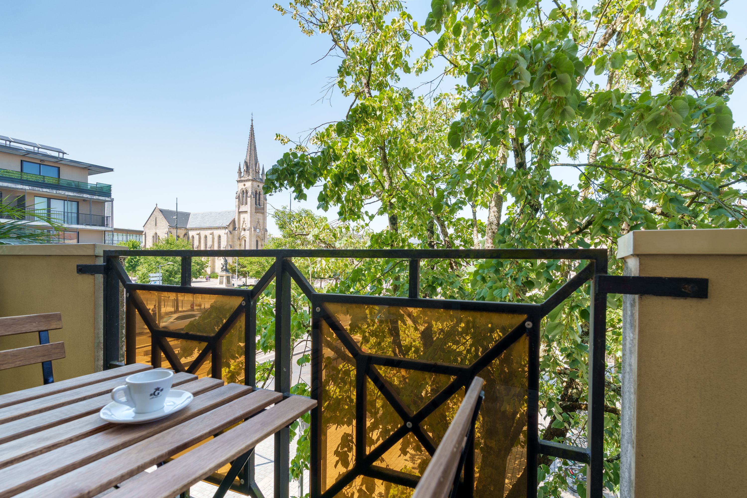 Terrasse du Douze au Soleil avec table bistrot et vue sur l'église de Mérignac