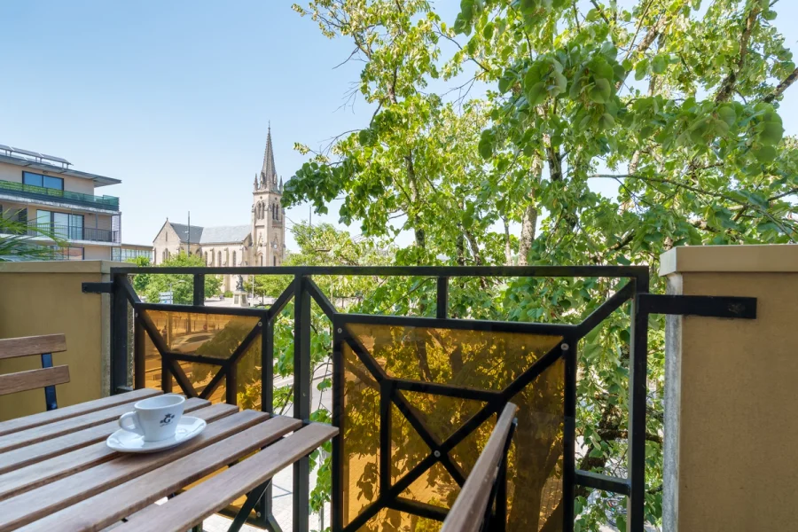 Terrasse du Douze au Soleil avec table bistrot et vue sur l'église de Mérignac