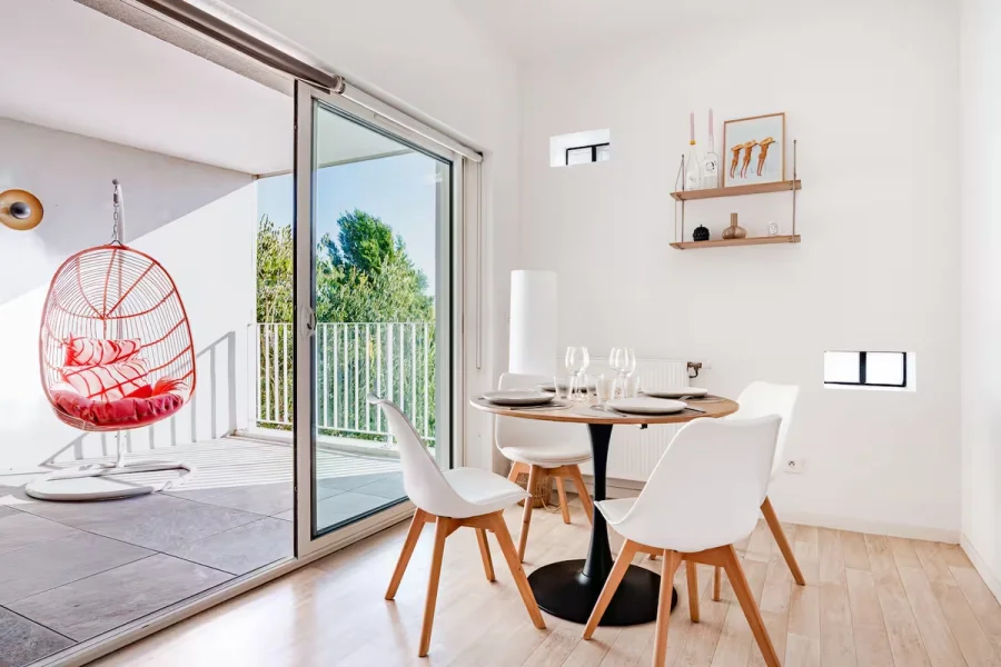 Coin repas de L'Échappée avec table ronde face à la loggia