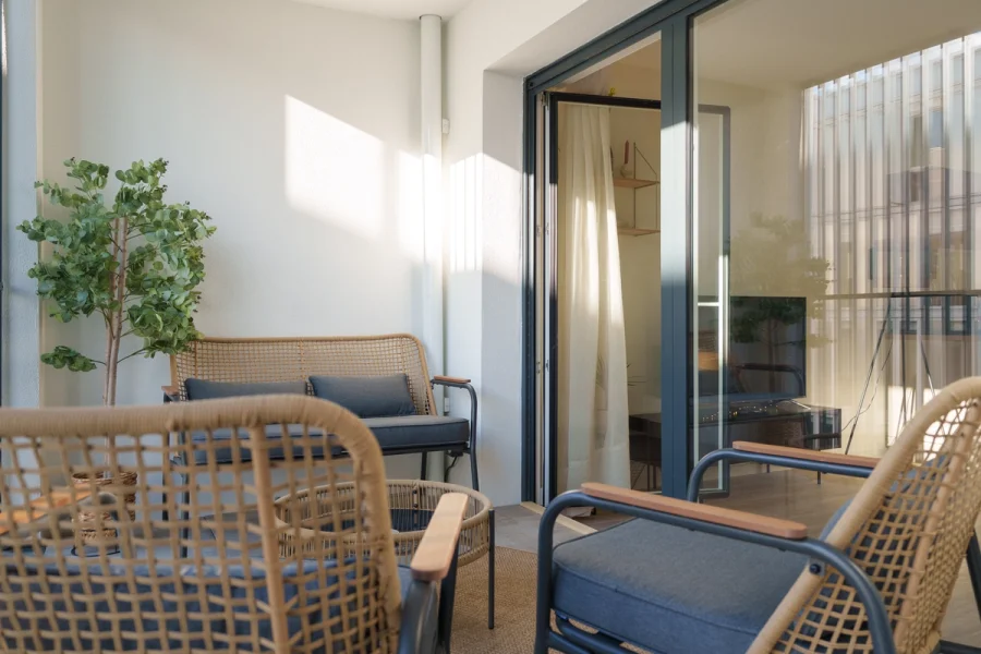 Loggia meublée avec fauteuils et canapé en fibres tressées