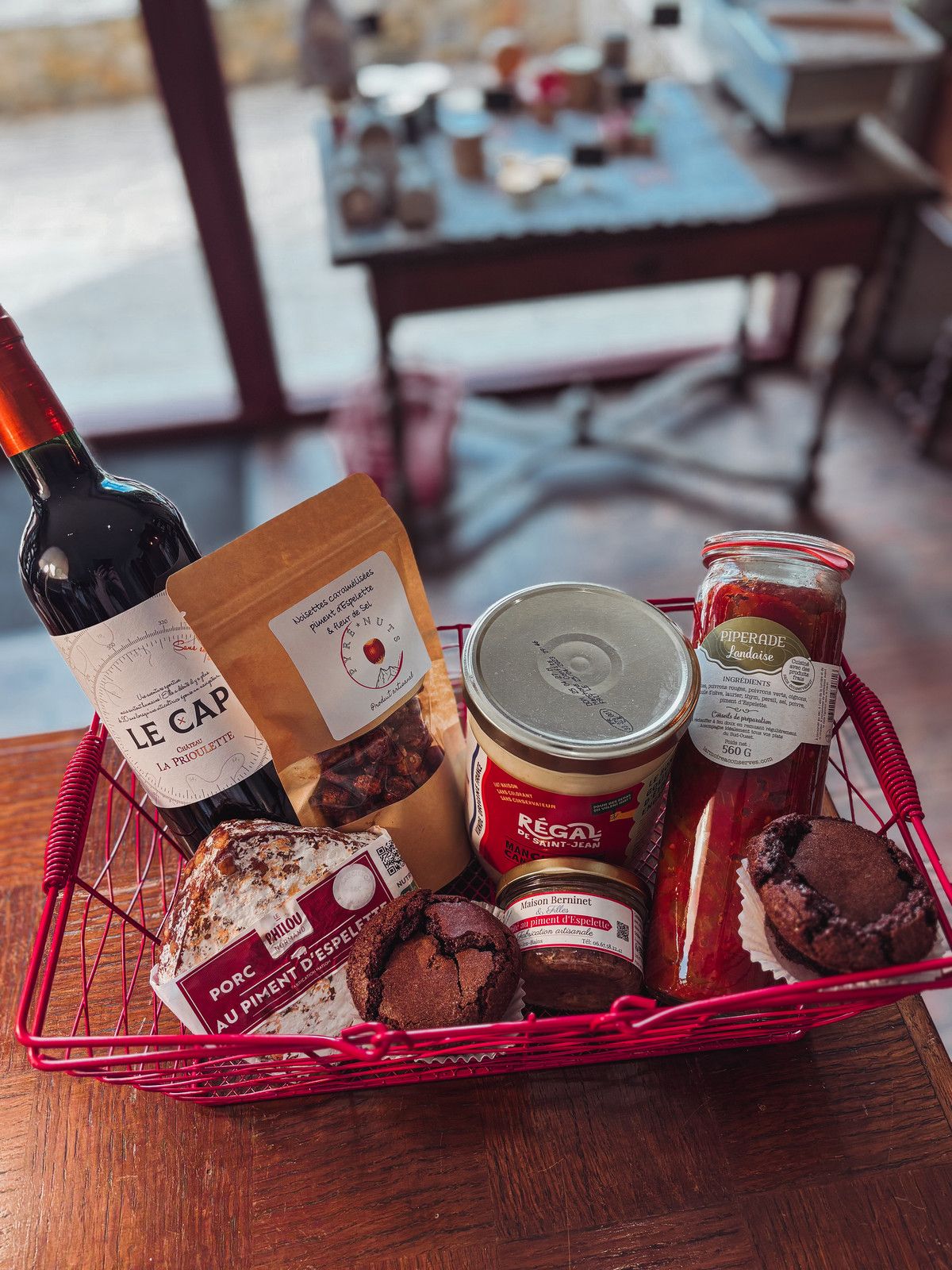 Panier garni d'une bouteille de vin, de confitures, de conserves et de gâteaux