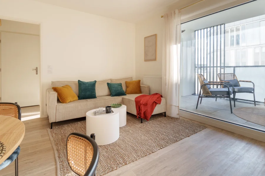 Salon avec canapé d'angle en velours côtelé, ouvert sur la loggia