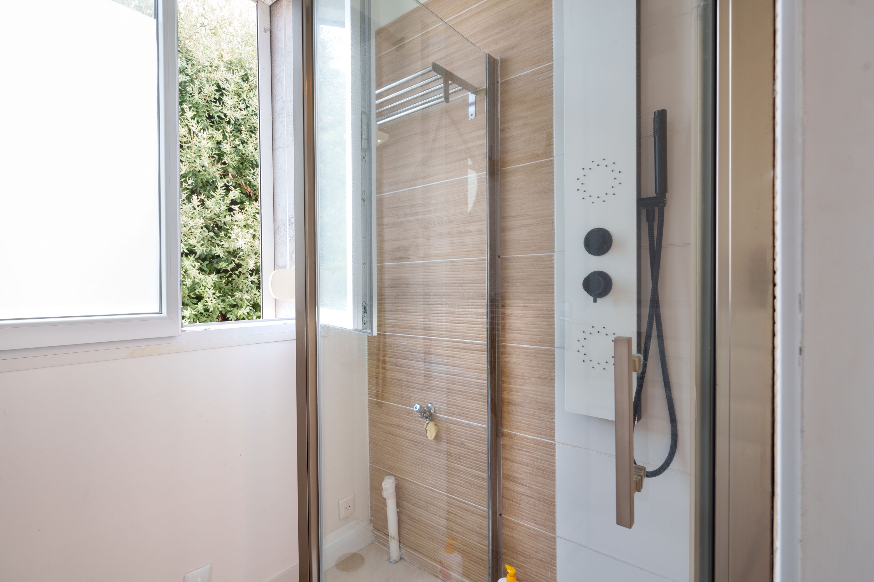 Grande douche avec colonne noire dans la salle de bain