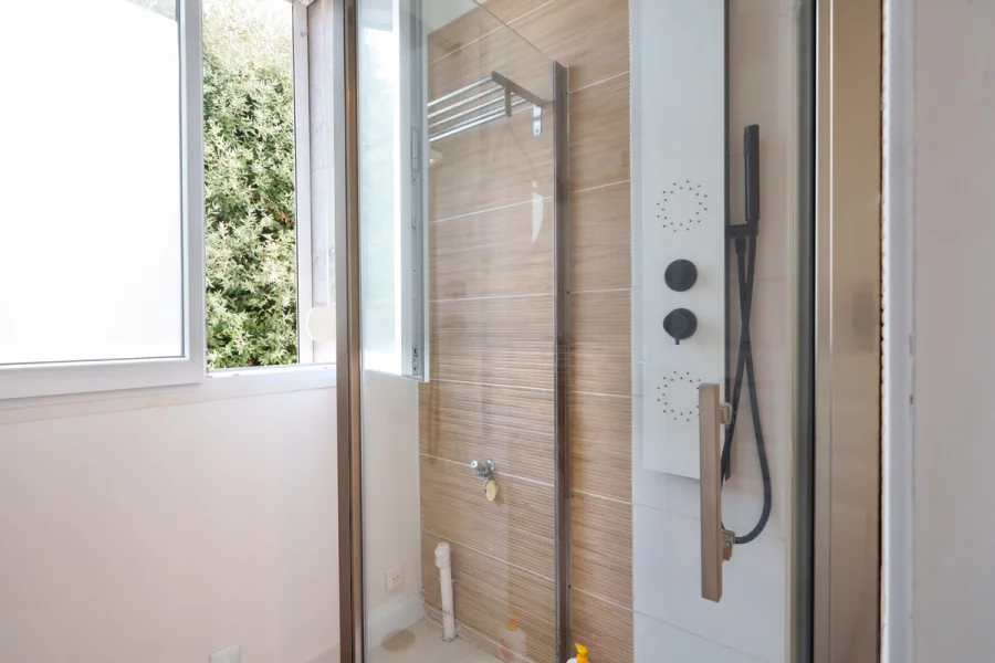 Grande douche avec colonne noire dans la salle de bain