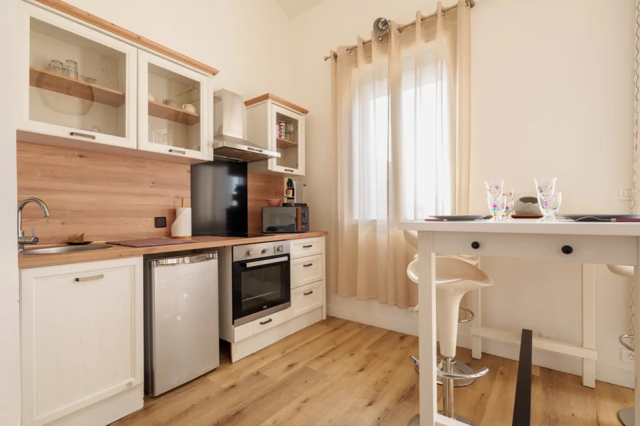 Cuisine équipée avec four, plaques de cuisson, machine à café et coin repas