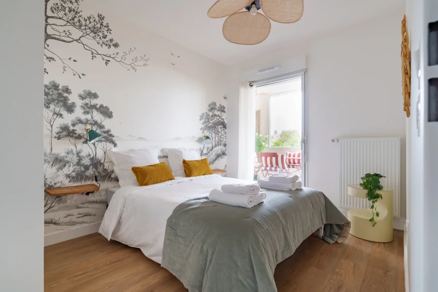 Chambre principale avec papier peint panoramique et accès terrasse
