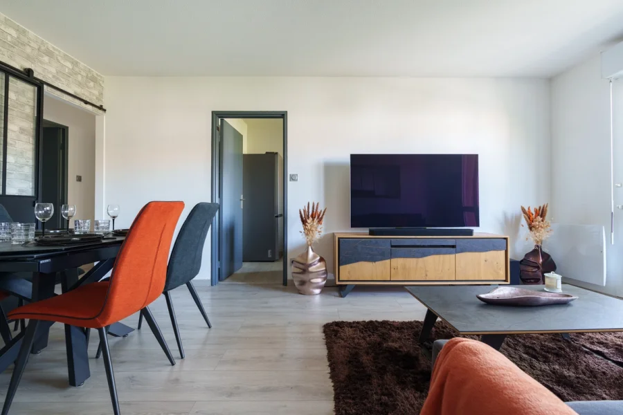 Séjour avec grande Smart TV, barre de son et meuble en bois