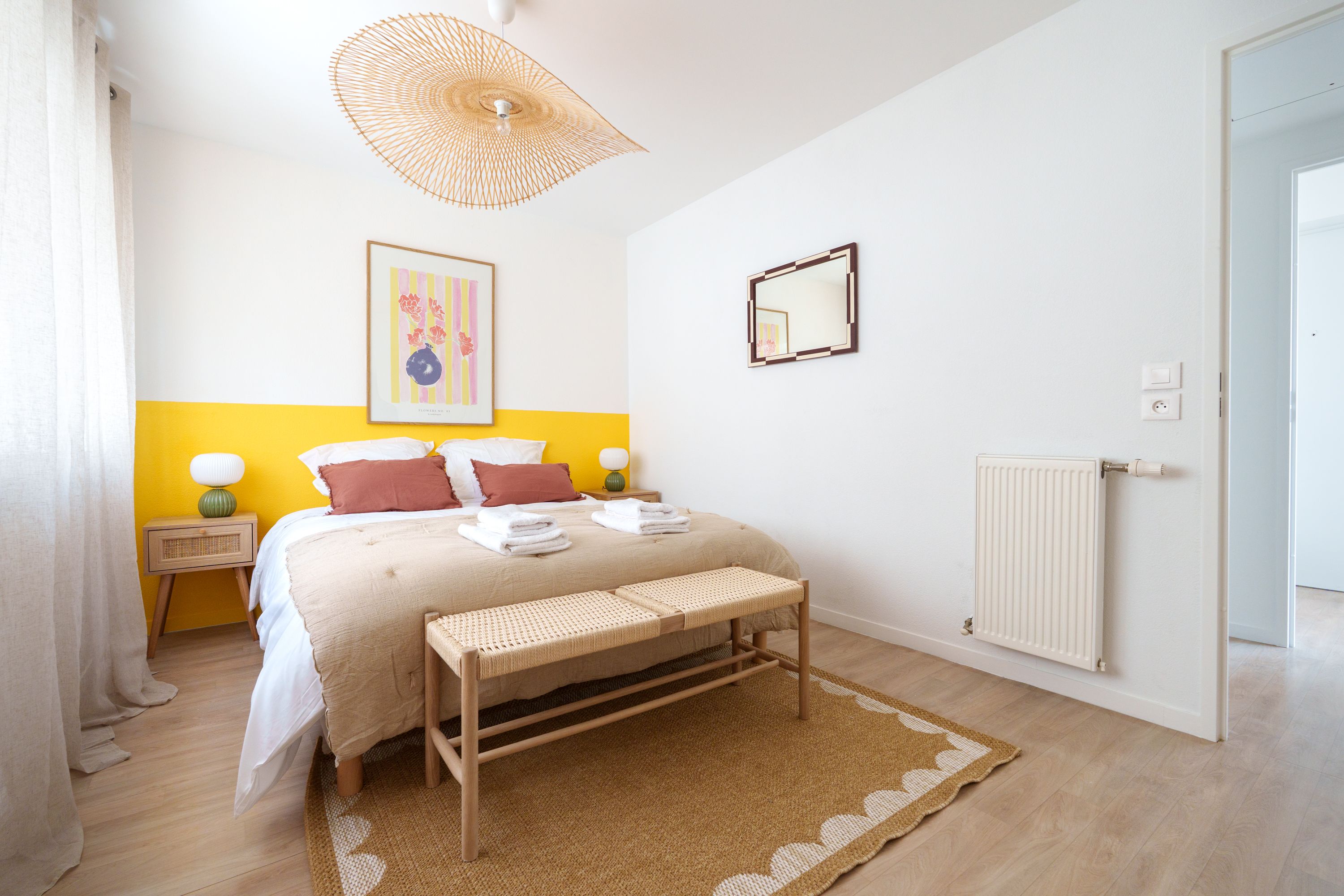 Chambre du Carré Lumière avec lit double, banc et tapis