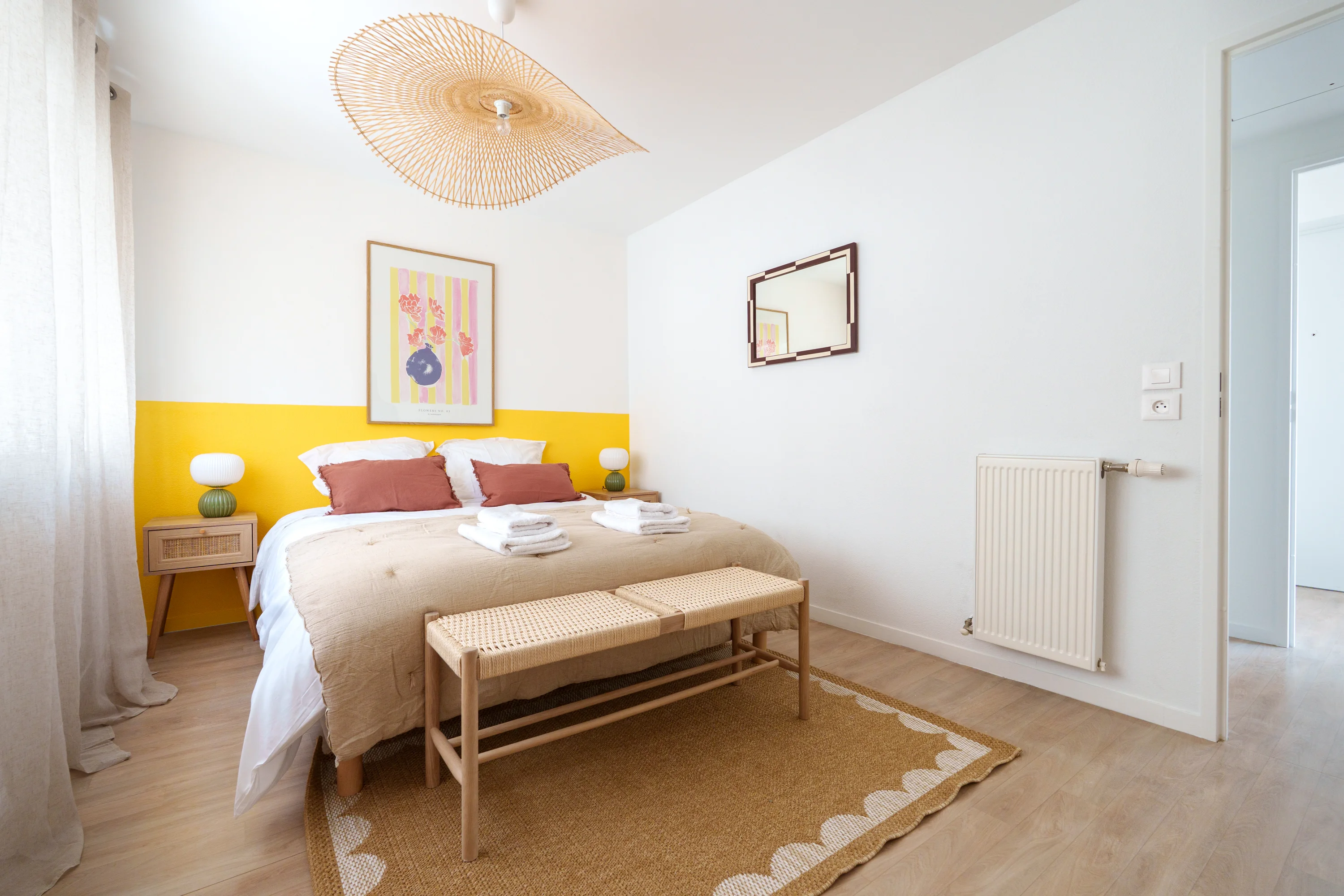 Chambre du Carré Lumière avec lit double, banc et tapis