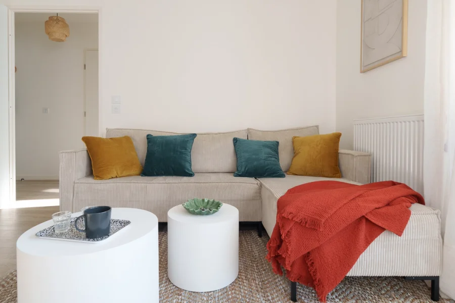 Canapé d'angle avec coussins colorés et plaid terracotta