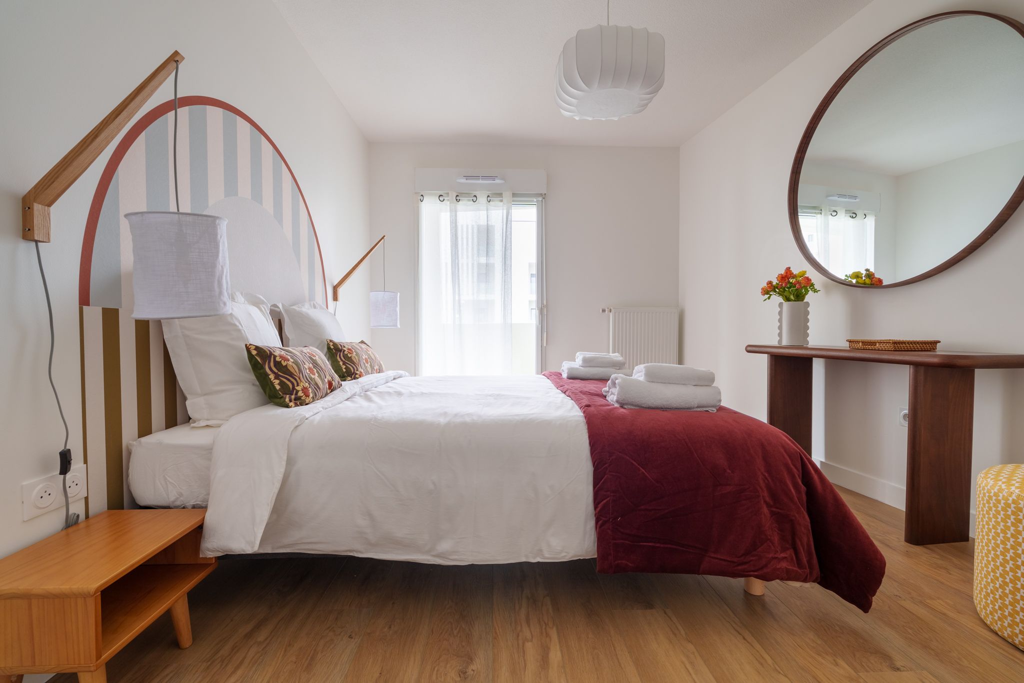 Seconde chambre avec tête de lit en arche et miroir rond
