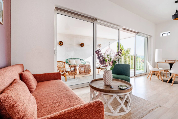 Séjour de L'Échappée avec canapé terracotta, ouvert sur la loggia