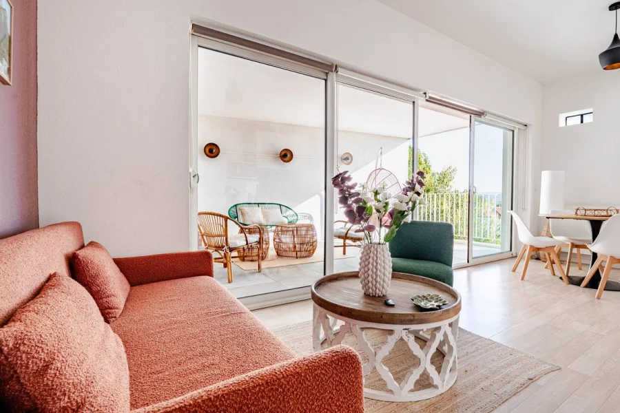 Séjour de L'Échappée avec canapé terracotta, ouvert sur la loggia