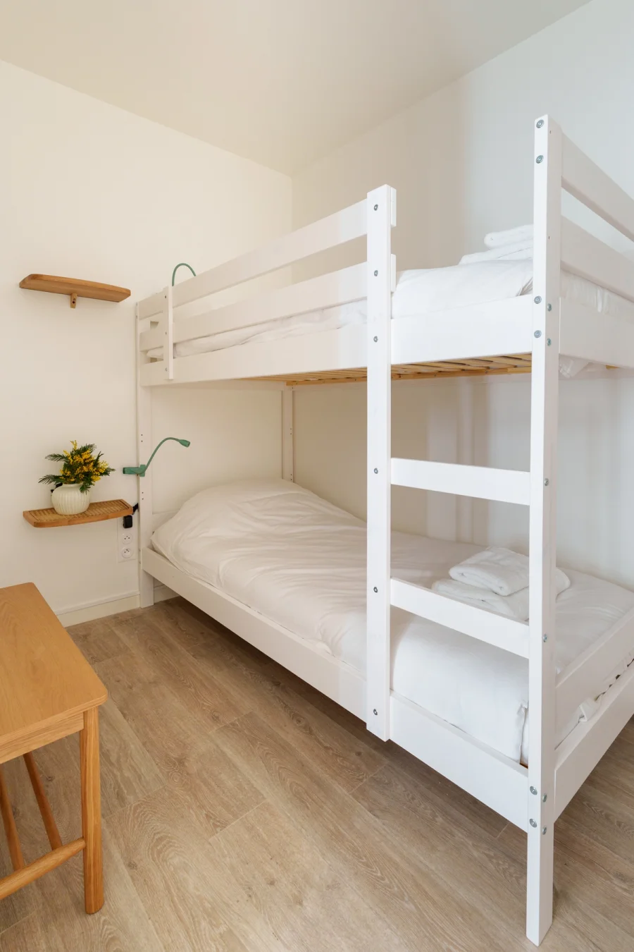 Chambre avec lits superposés, serviettes pliées et liseuses