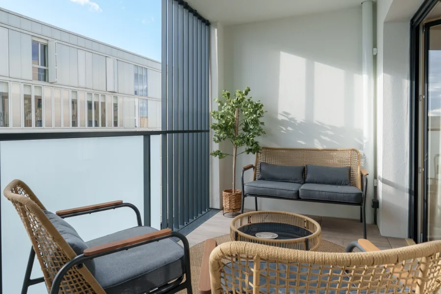 Loggia avec salon de jardin en résine tressée et plante verte