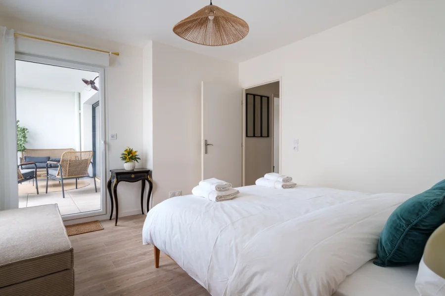 Chambre principale avec lit double, ouverte sur la loggia meublée