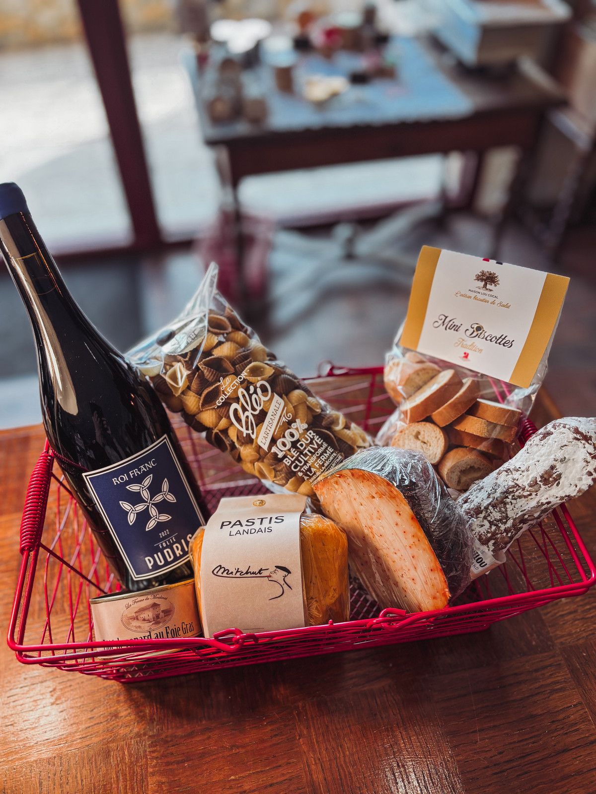 Panier apéritif avec une bouteille de vin, du fromage et des biscuits