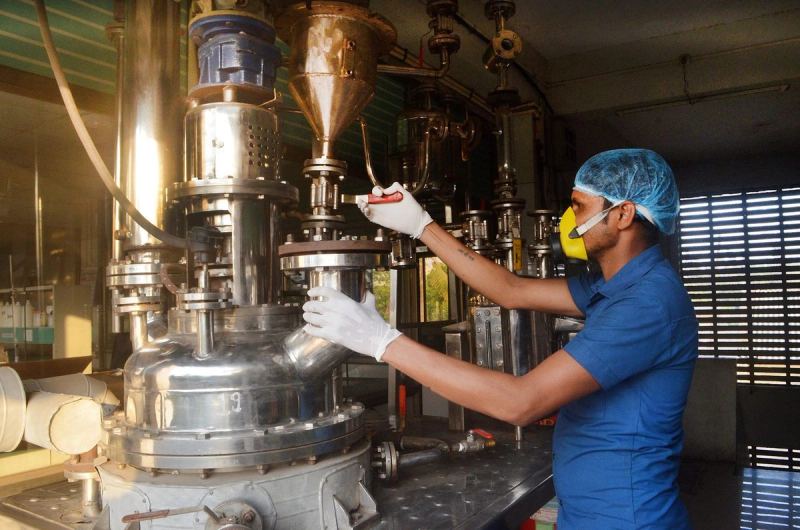 Operator working at a stainless steel reactor on the Colortek production floor