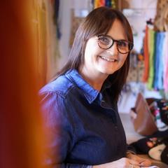 Kathrine Gregersen står ute i ein kvit genser med eit fargerikt, brodert motiv på brystet