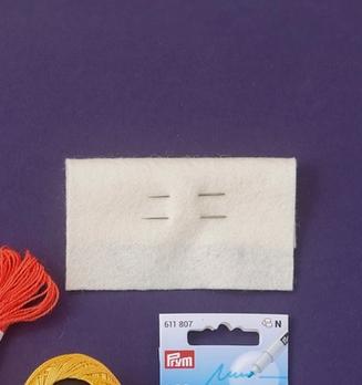 Materialpakke til adventskalender med filt, garn, nålar, merkepenn og eit hefte på lilla bakgrunn
