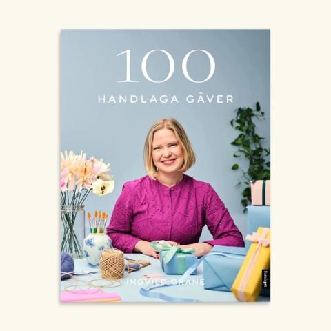 Bokomslag for 100 handlaga gåver av Ingvild Grane med smilande kvinne omringa av heimelaga gåver og hobbymateriell