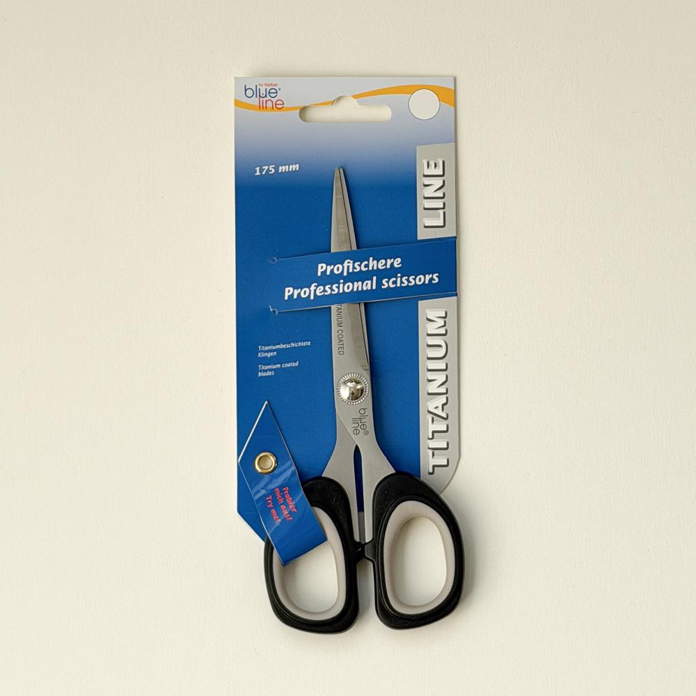 Skreddarsaks i stål og svart plast festa på blå pappeske med teksten professional scissors