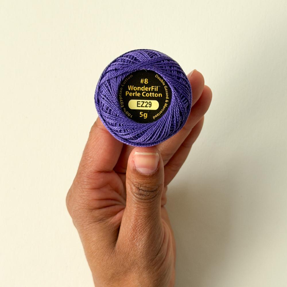 Ei hand held ein lilla hespe med perlegarn merkt wonderfil perle cotton EZ29