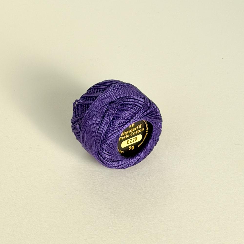 Liten lilla nøste med perlegarn merkt WonderFil Perle Cotton EZ29 på ein lys bakgrunn
