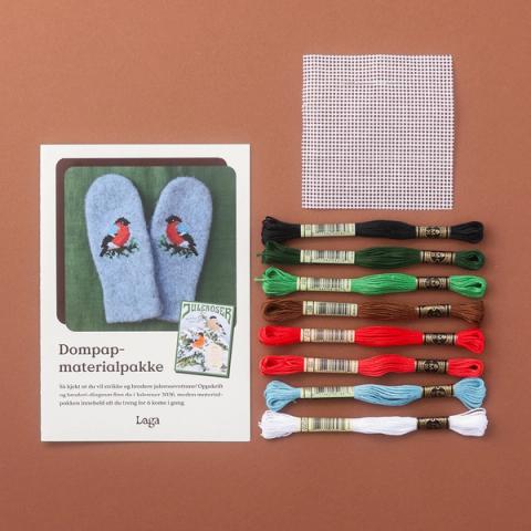 Materialpakke for broderi med oppskrift, garn i ulike fargar, stramamin og nål på brun bakgrunn