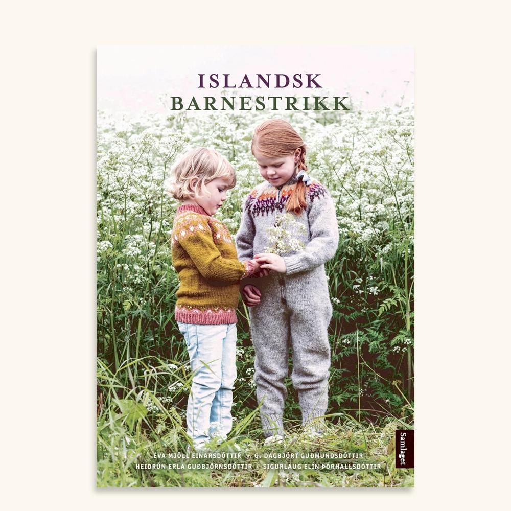 Bokomslag med tittelen Islandsk barnestrikk som viser to born i strikkaklede ståande ute i ein eng med kvite blomar