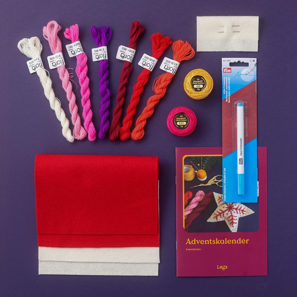 Materialpakke med filt, ullgarn i ulike fargar, Nål, blyant og eit hefte merkt Adventskalender på lilla bakgrunn