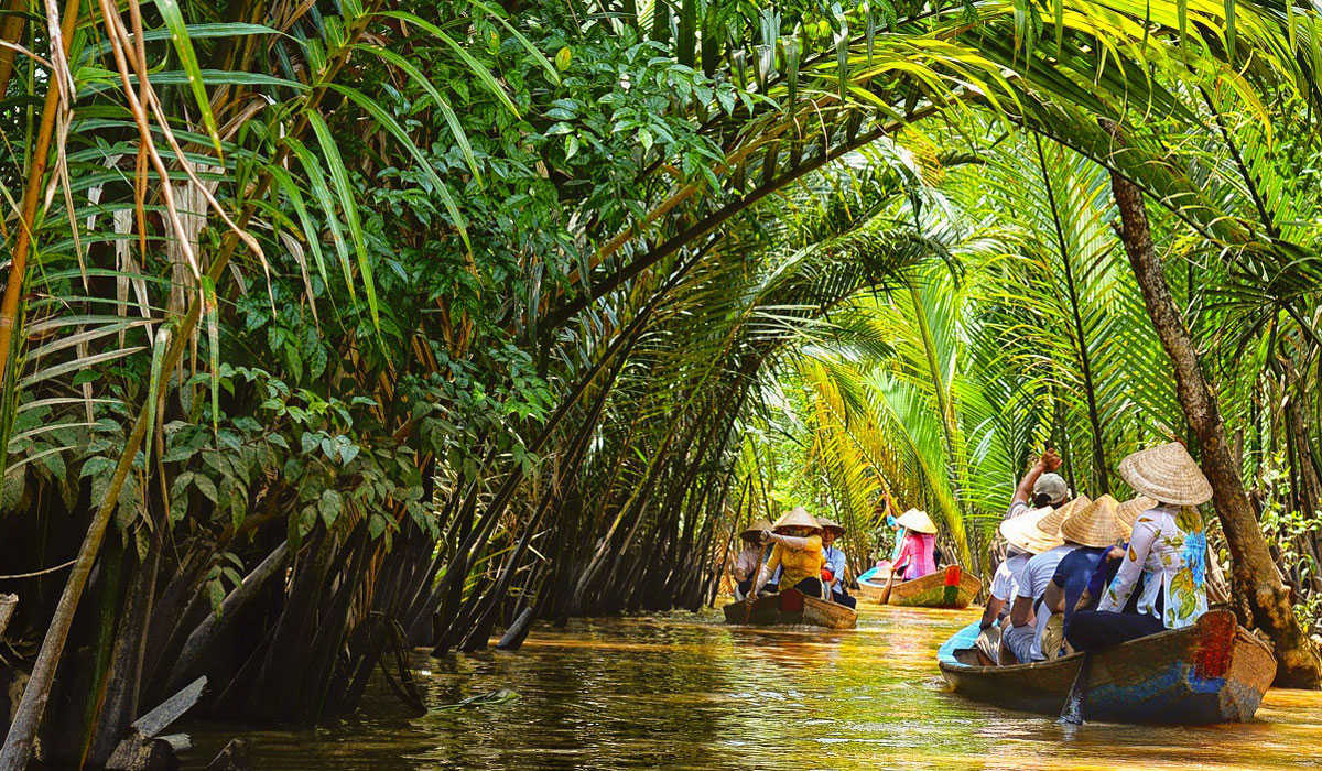 Women rowing a small boat along a My Tho Mekong Delta waterway