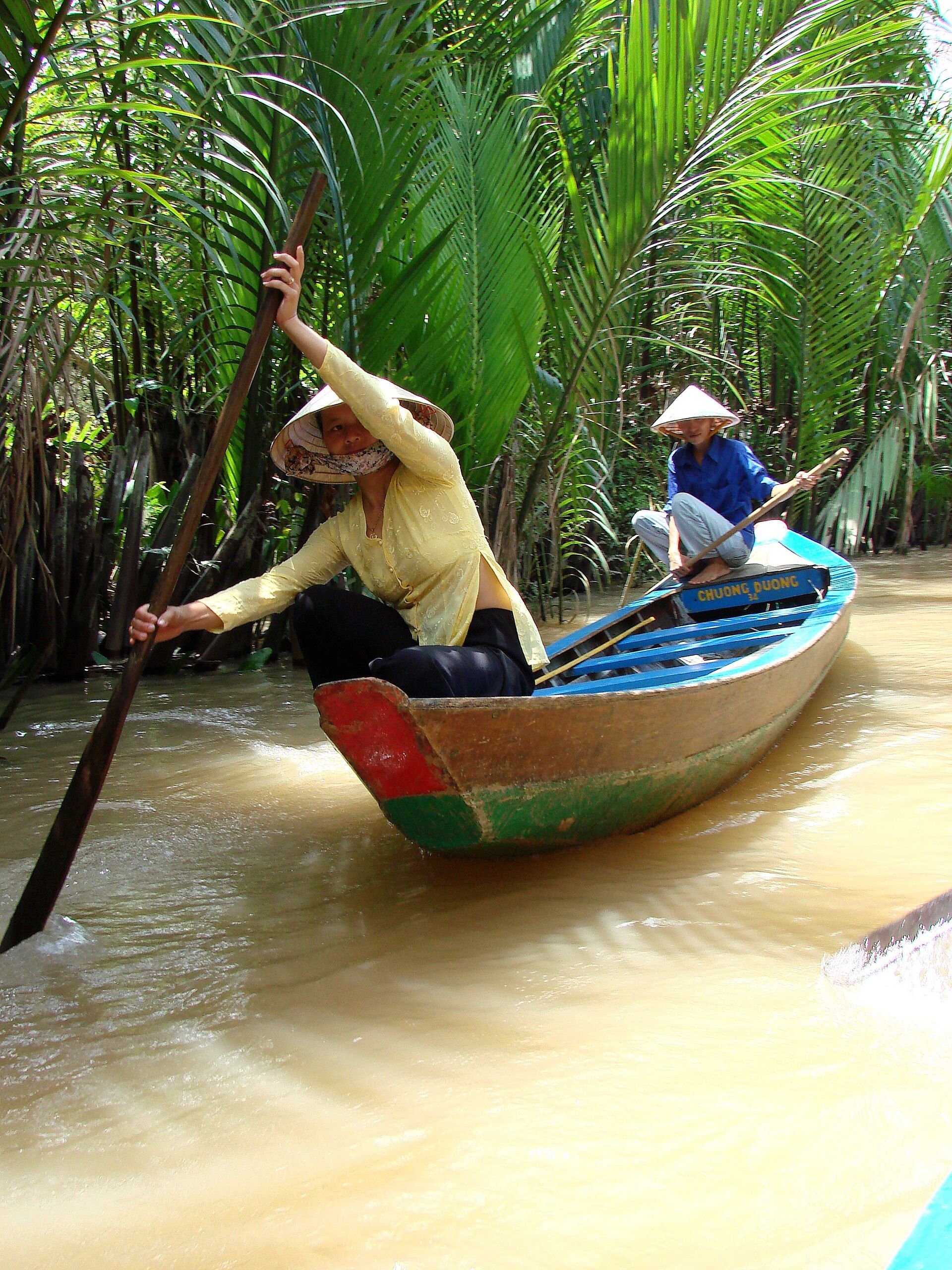 Women rowing a small boat along a My Tho Mekong Delta waterway