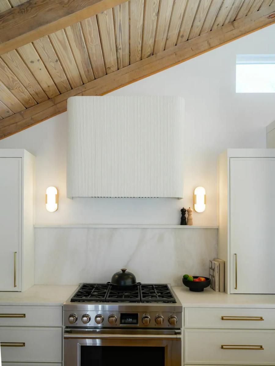 Plaster range hood with a fluted front and sconces