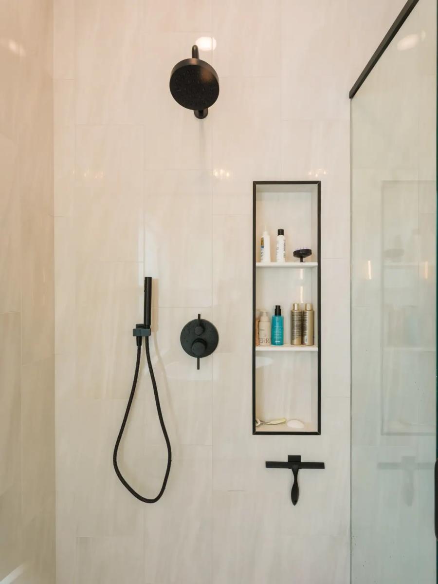 Plaster-finish shower with a tall niche and black fixtures