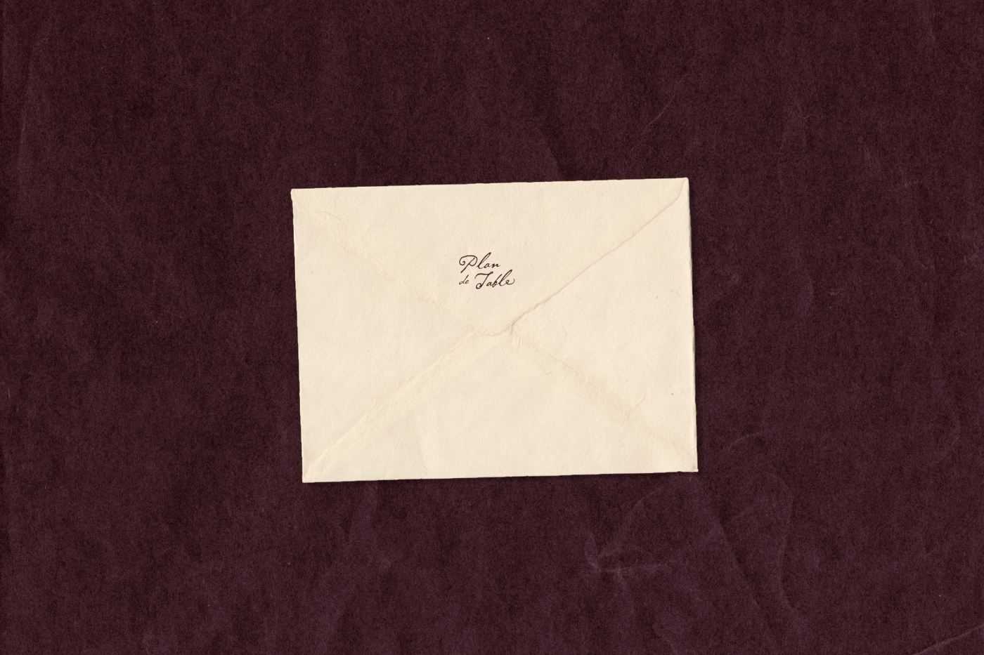 A cream envelope with logo, centered on a dark plum textured background.