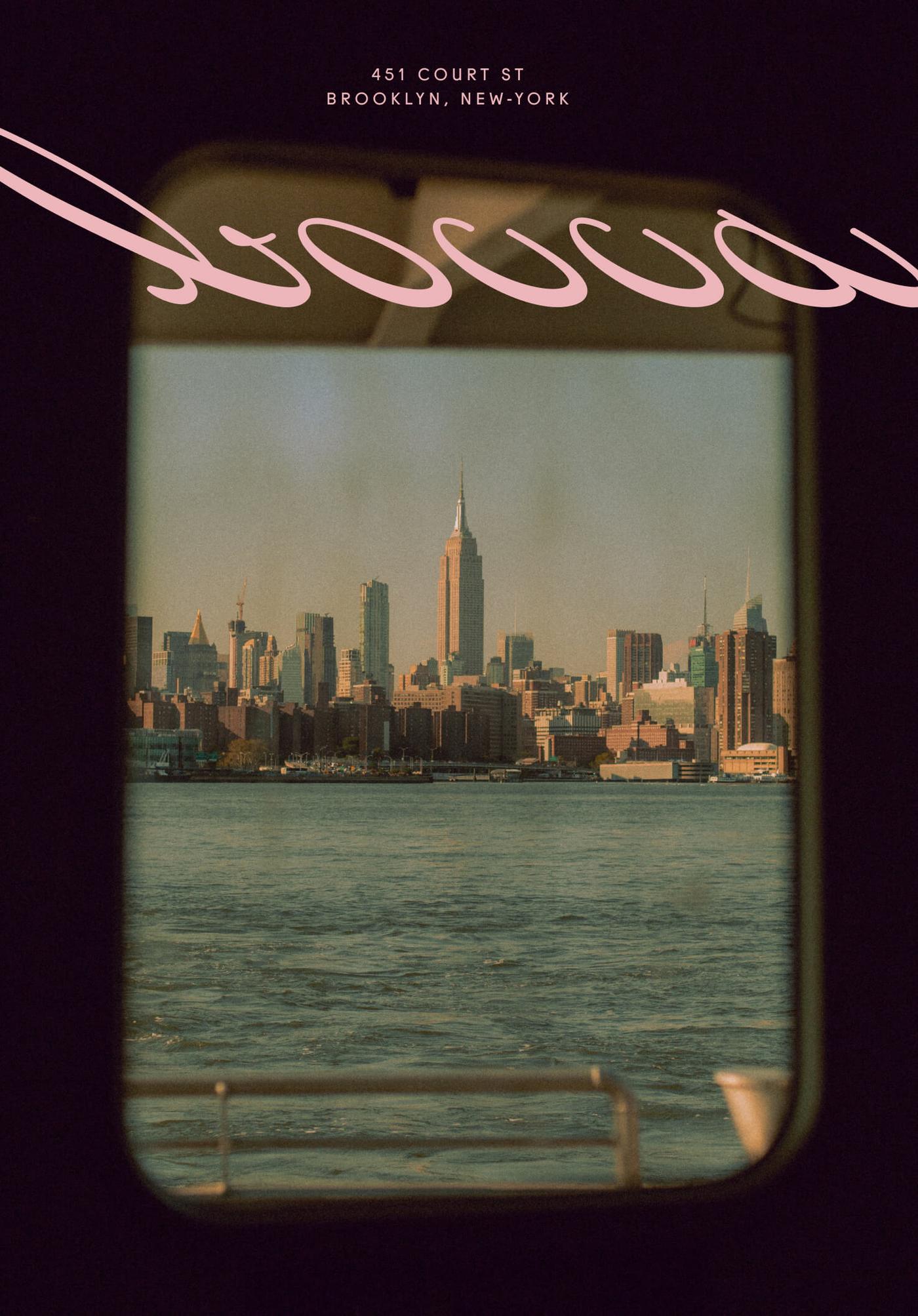 View through a round ferry or boat window showing the Manhattan skyline across the water, with the pink cursive "Bocca" logo and address curving across the glass.