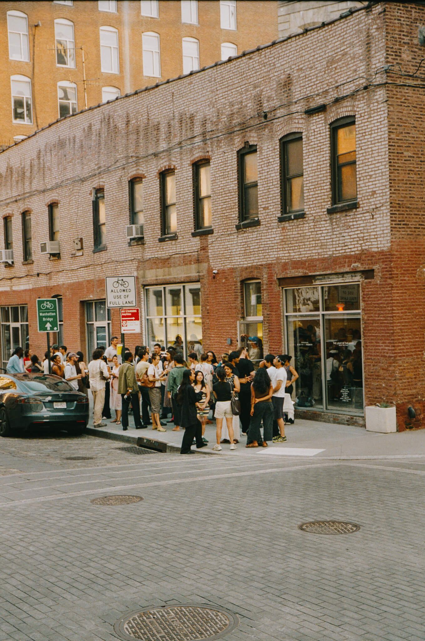 Exterior of a brick building in Brooklyn (Hudson Wilder store) with a crowd gathered outside for the launchevent.