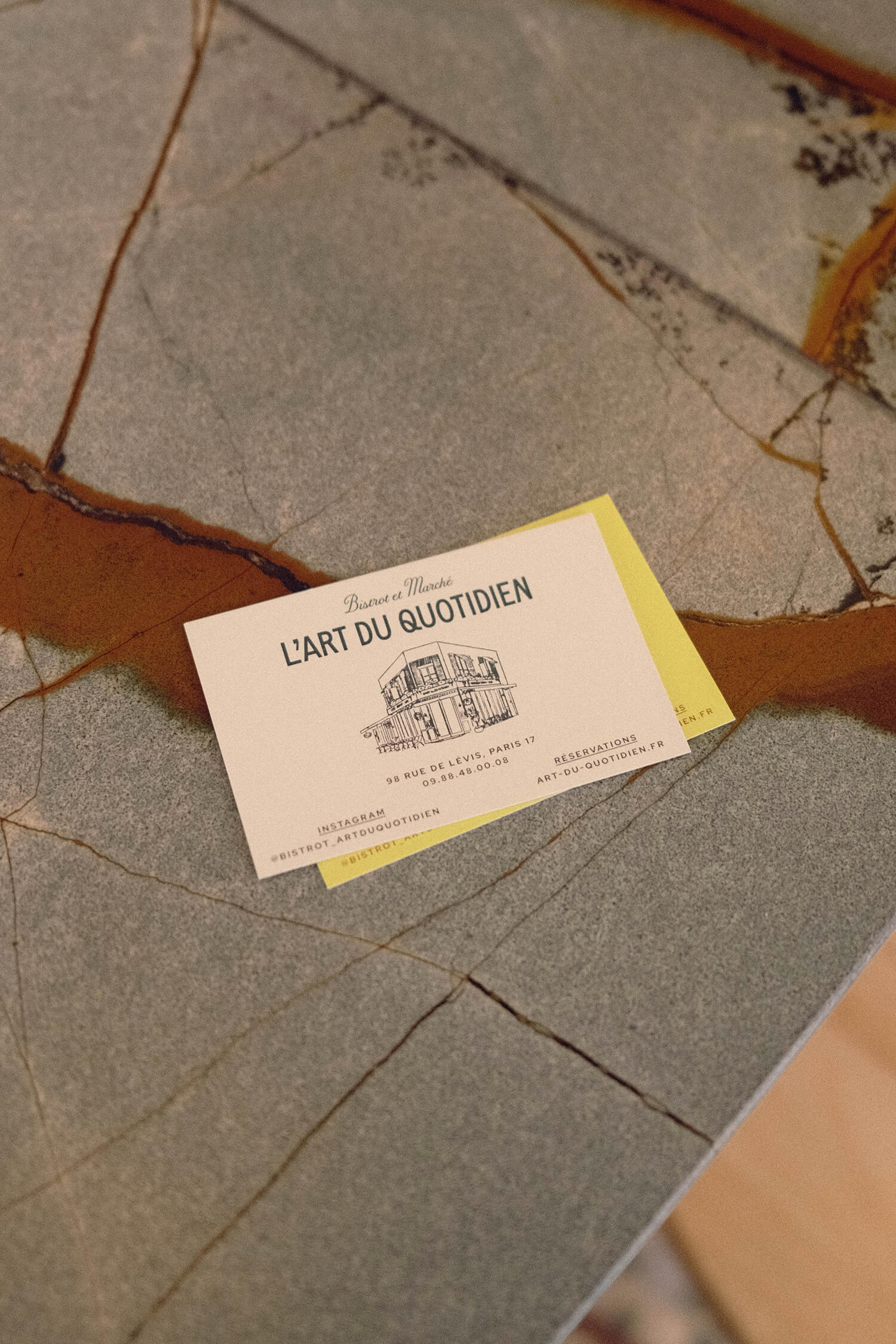 Business cards photographed on a textured stone surface.