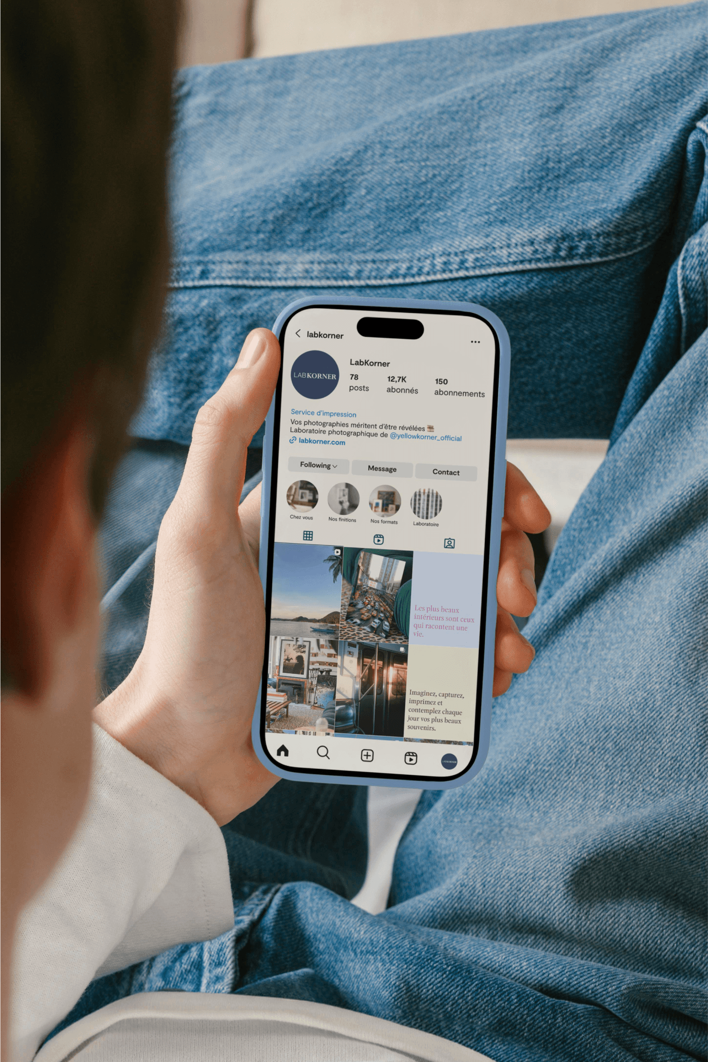 Close-up over the shoulder of someone holding a phone showing the LabKorner Instagram profile.