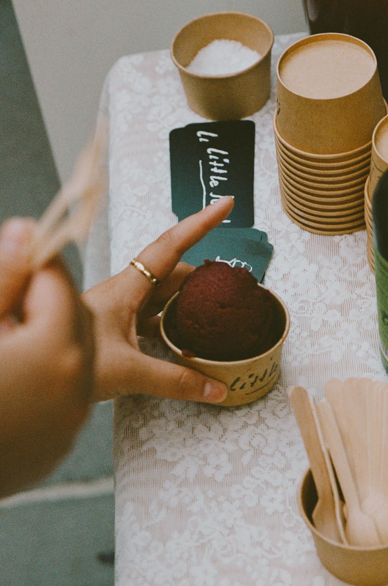 A hand holding a small ice cream by Little Rat Ice Cream in a paper cup at the launch event.