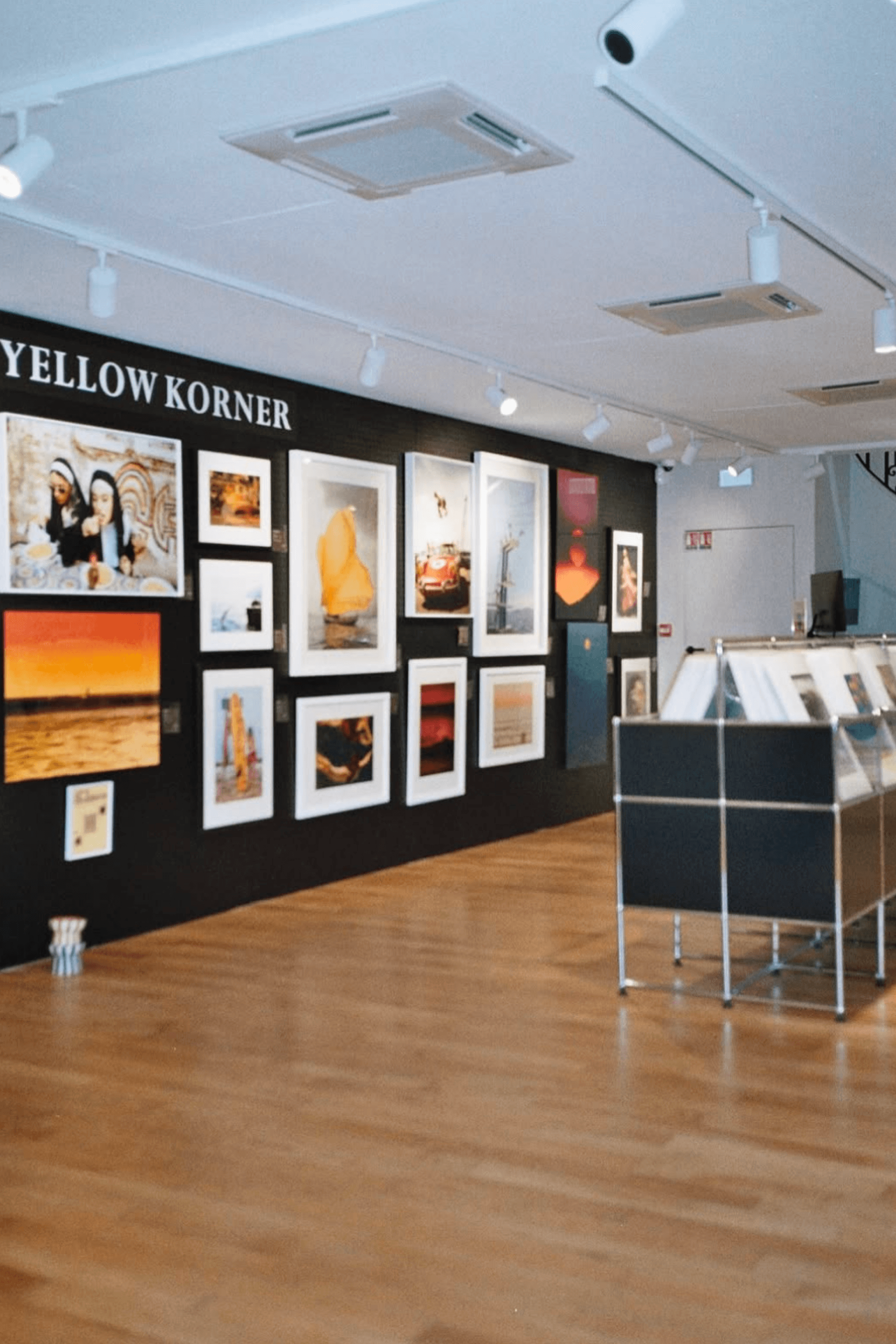 La Hune gallery featuring a selection of photographs displayed on a black wall, with exhibition stands in the centre of the room.