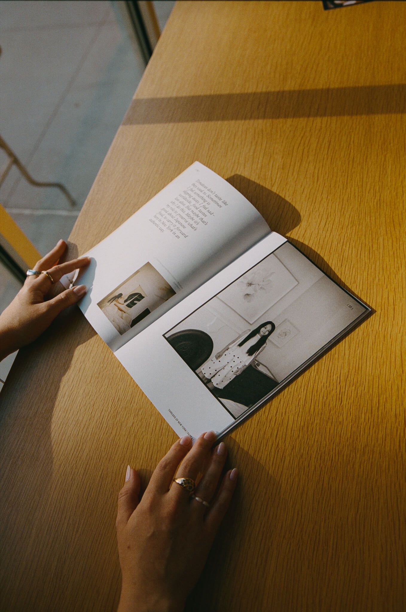 Right: close-up of hands turning the pages of the open journal, showing a photo spread, on a sunlit wooden surface.