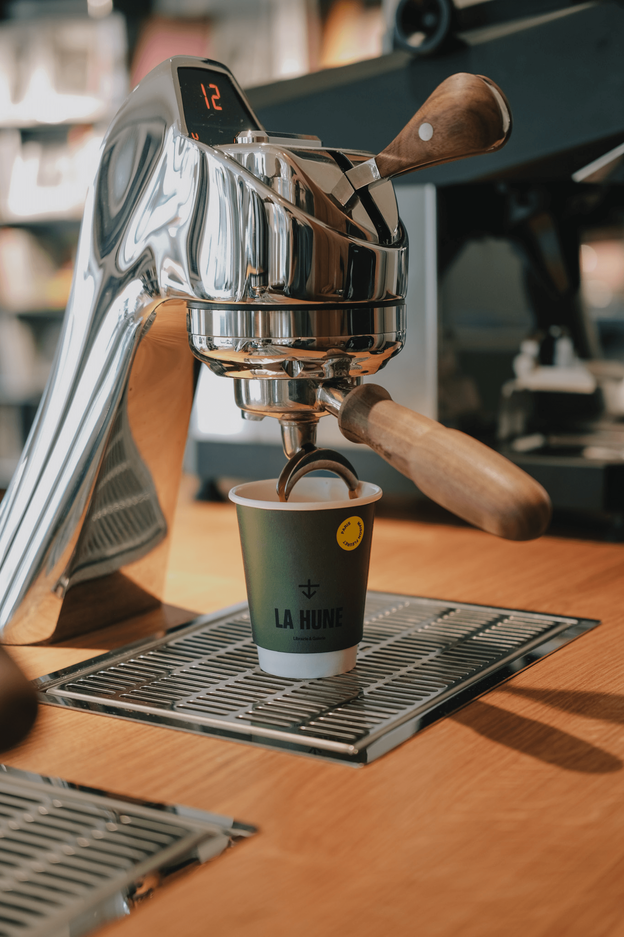 Espresso being poured into a La Hune coffee cup from a professional coffee machine.