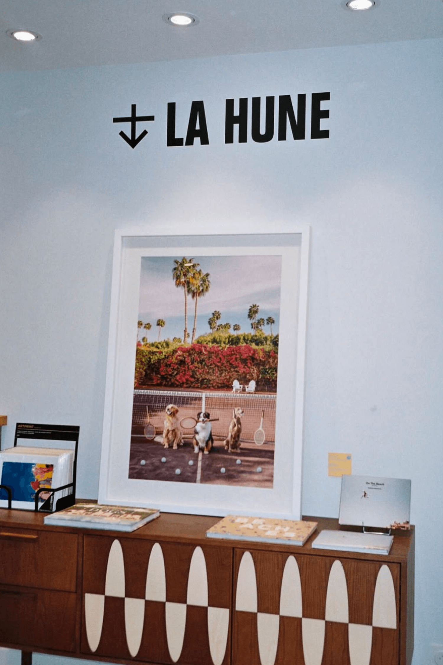 Interior of La Hune featuring a large framed photograph, the La Hune logo on the wall, and a wooden display cabinet.