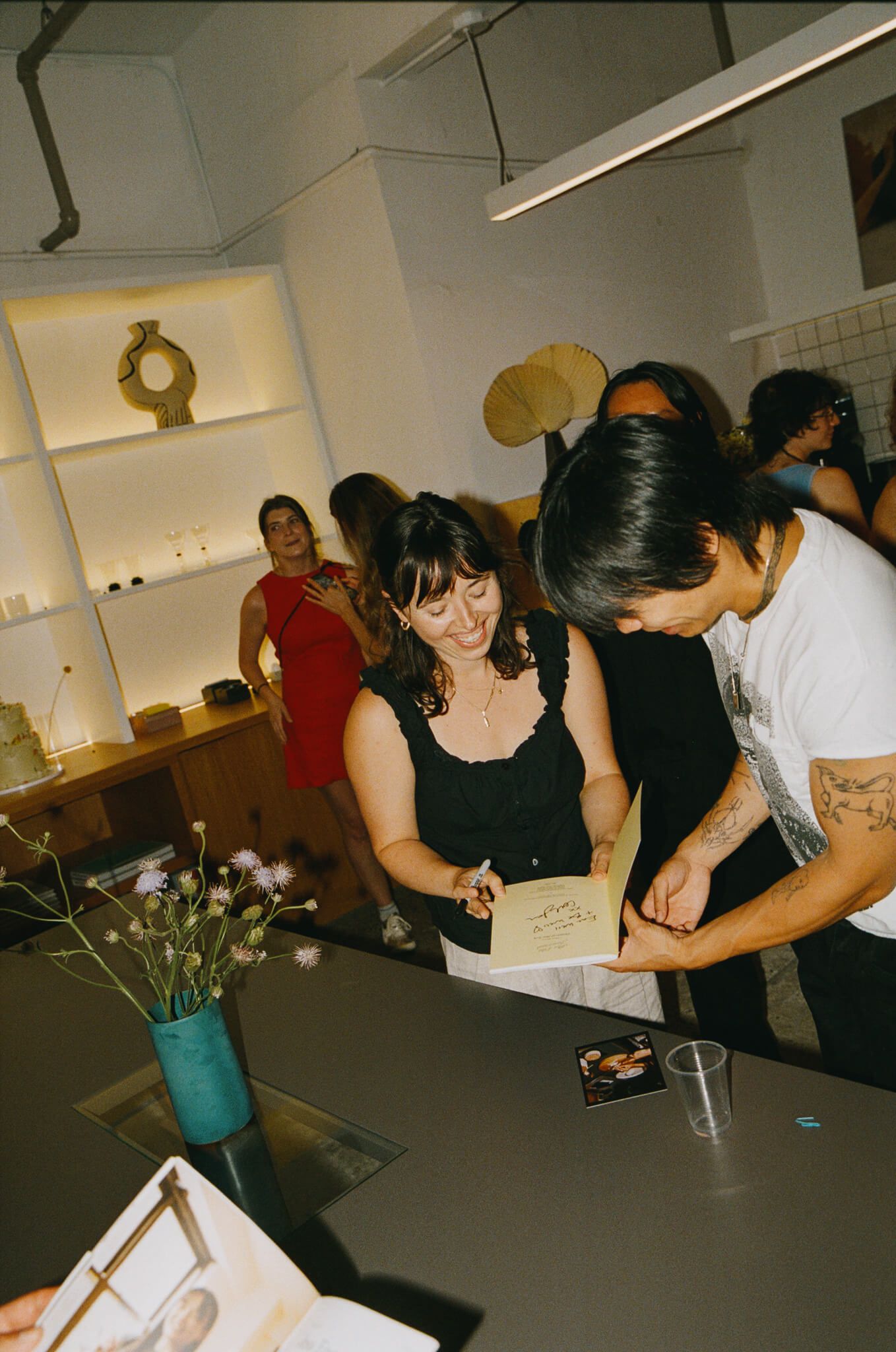 Interior shot of guests browsing a display shelf inside the venue, and founder Carli Gordon.