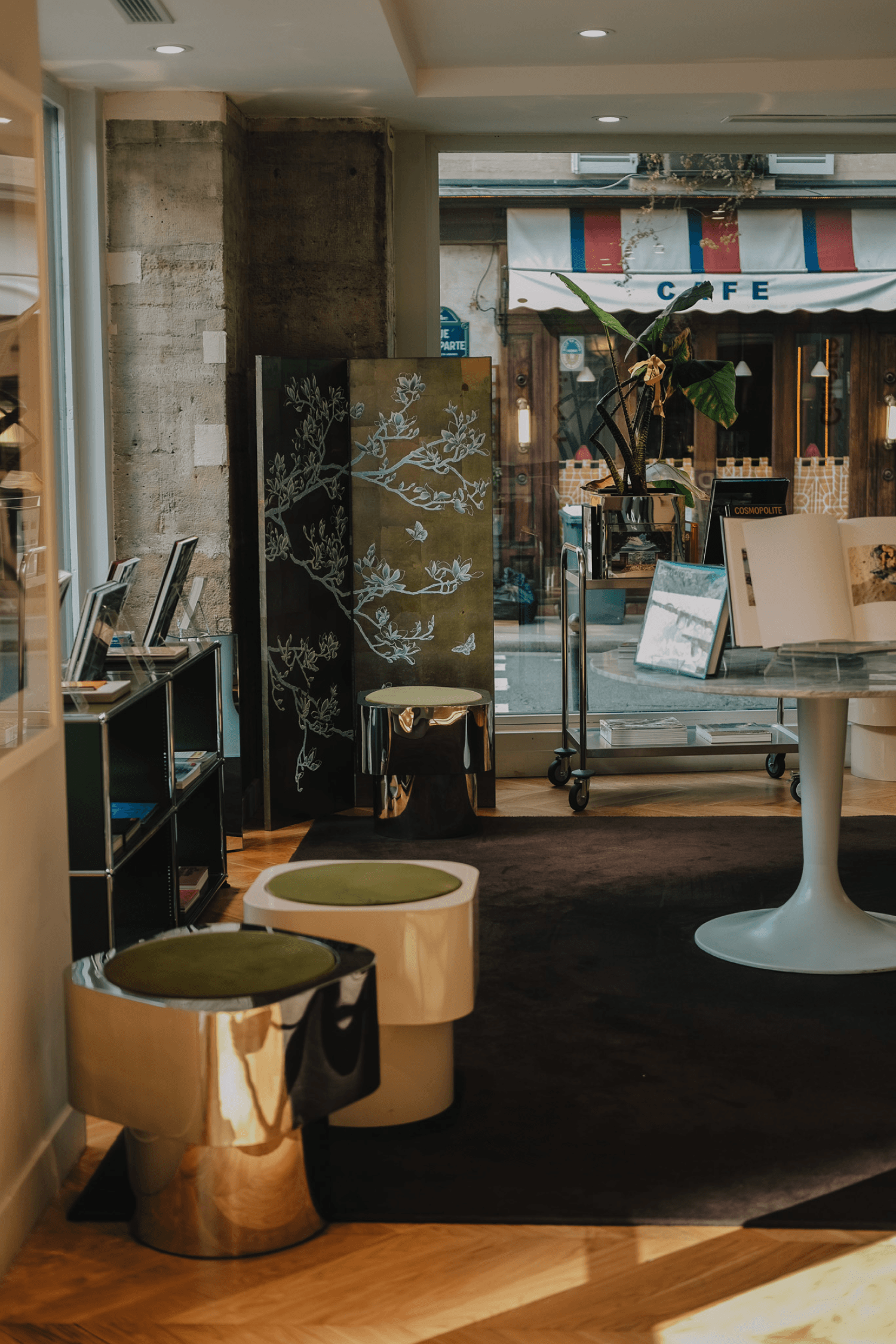Interior of La Hune café and bookstore, with seating areas, bookshelves and a table.