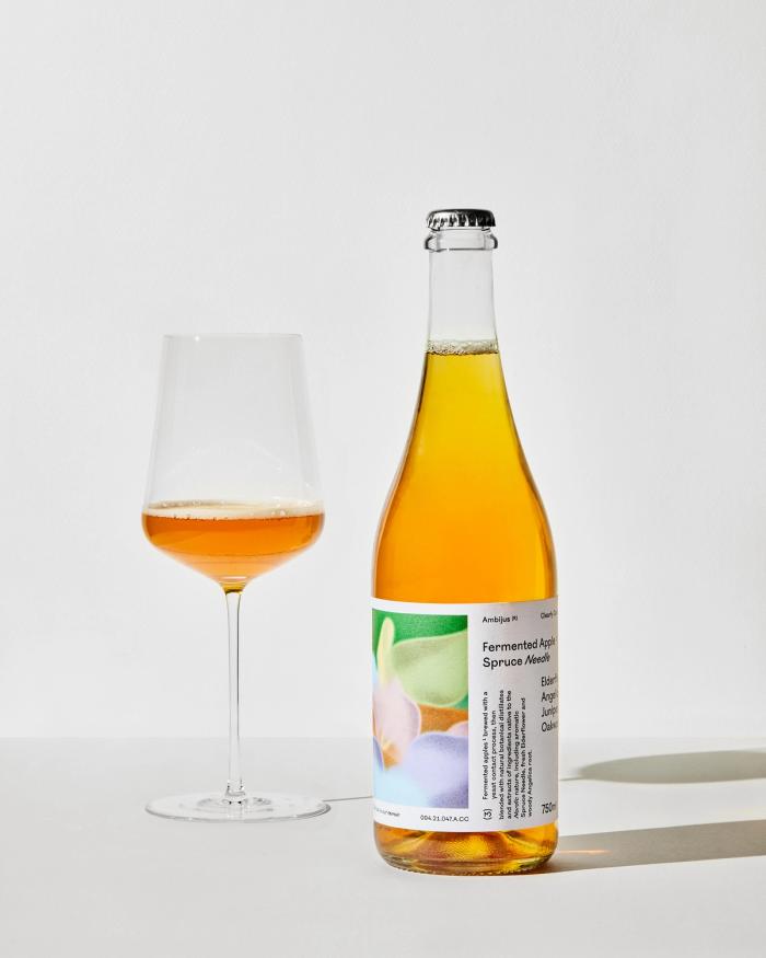 Bilde av en flaske Ambijus med et glass med stett ved siden av 