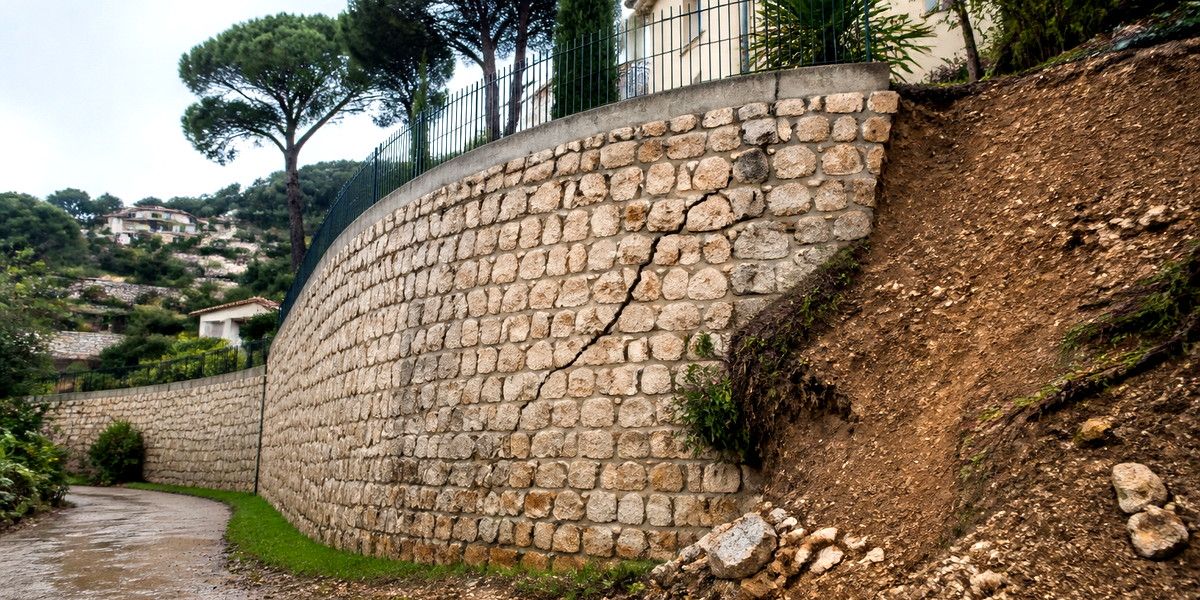 Mur de soutènement fissuré et terrain déstabilisé sur une colline résidentielle de Vallauris.